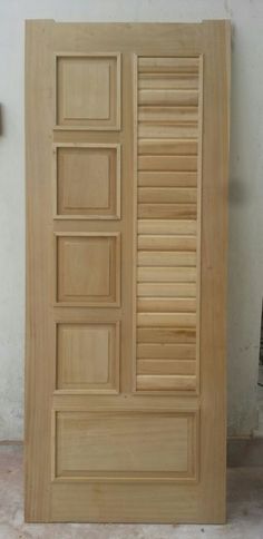 an unfinished wooden door with shutters on the side