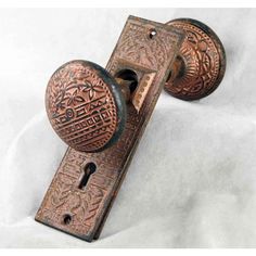 an antique door handle with intricate designs on it's side and two knobs