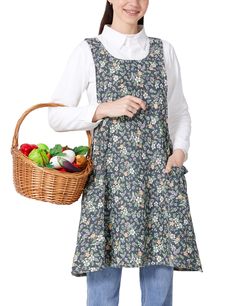 a woman in an apron holding a basket full of vegetables and smiling at the camera