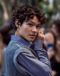 a close up of a person wearing a shirt and tie with his hand on his chin