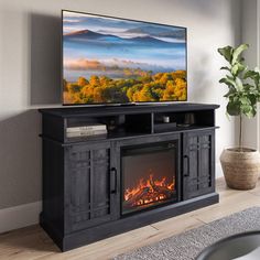 a flat screen tv sitting on top of a wooden entertainment center next to a fire place