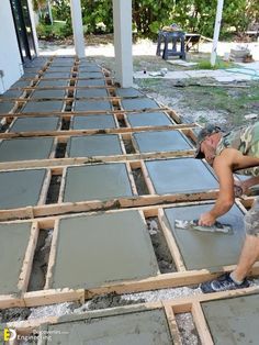 two men laying tile on the ground