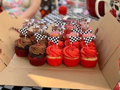 cupcakes with red frosting and black and white checkered flags on them