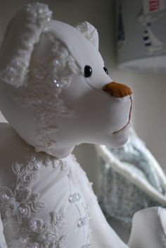 a white teddy bear wearing a wedding dress