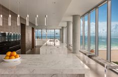 a large kitchen with marble counter tops next to the ocean