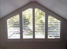 an open window with white shutters in a room