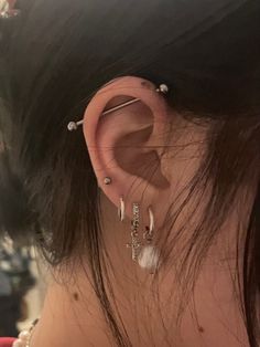 the back of a woman's head with ear piercings