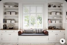 a window seat in the middle of a room with built - in bookshelves