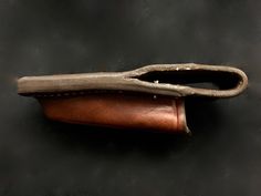 an old pair of scissors sitting on top of a black table next to a leather case