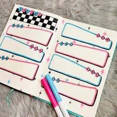 an open notebook with stickers on it and a pen laying next to the pages