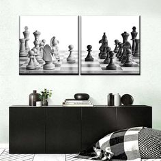 two black and white chess pieces on a wall next to a dresser with a checkered blanket