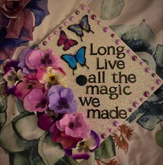 a graduation cap with flowers and butterflies on it that says long live all the magic we made