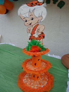 there is a cake that looks like a cartoon character on top of a tiered cake