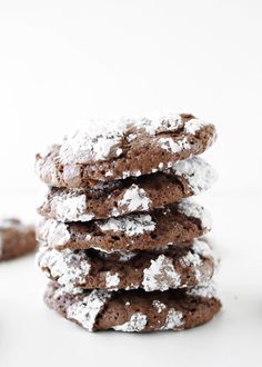 chocolate crinkle cookies stacked on top of each other with powdered sugar on them