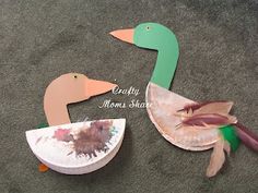 two paper plates shaped to look like ducks on the ground, one with its beak open