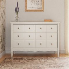 a white dresser sitting next to a window in a room