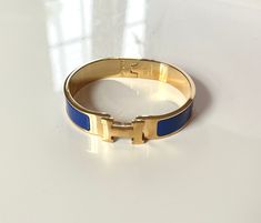 Gold H Cuff Bracelet in Royal Blue Blue Cuff Bracelet Gift, Adjustable Blue Cuff Bracelet, Adjustable Blue Cuff Bangle, Blue Hermes Bracelet, Hermes Bracelet, School Jewelry, Cuff Bracelet, Royal Blue, Bangles