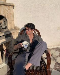 a man sitting on a bench holding a coffee cup