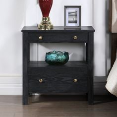 a black table with two drawers and a red vase on the bottom shelf next to it