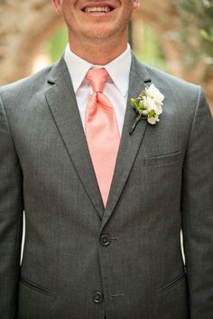 a man in a gray suit and pink tie