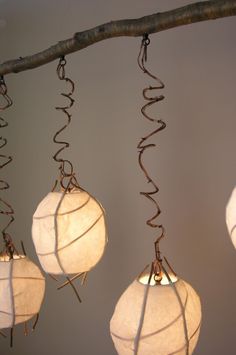 three white paper lanterns hanging from metal wires