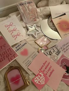 pink and white greeting cards on a bed with a gold frame, mirror, and other items