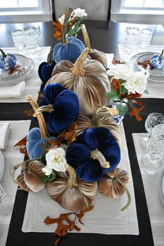 the table is set with blue and white pumpkins