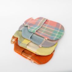 four different colored plaid flannels stacked on top of each other