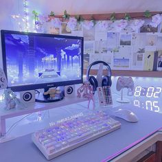 a computer monitor sitting on top of a desk next to a keyboard and headphones