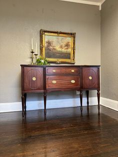 a painting on the wall next to a wooden dresser