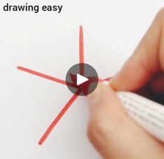 a person is drawing with red pencils on white paper and has an eraser in front of them