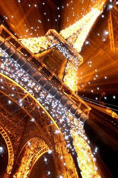 the eiffel tower lit up at night with lights on it's sides