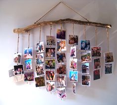 a group of photos hanging from a wooden stick on a wall with clothes pins attached to them