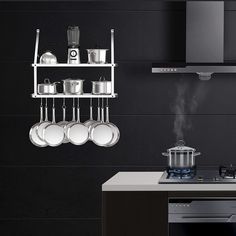 pots and pans are hanging on the wall above the stove in this modern kitchen