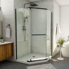 a bathroom with a walk in shower next to a sink and bathtub, along with a rug on the floor