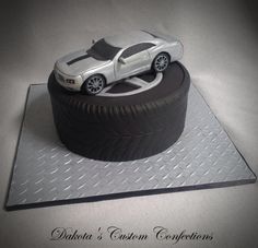 a cake made to look like a car on top of a tire with the word deltata's custom confections