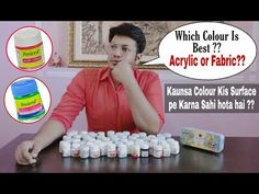 a man is sitting at a table with many bottles on it and the caption says, which color is best? acrylic or fabric?