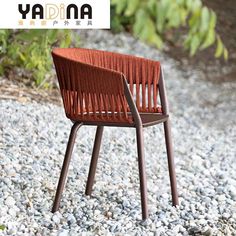 a wooden chair sitting on top of a gravel covered ground