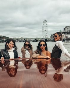 four women are sitting on a boat in the water