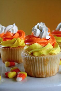 several cupcakes with white and orange frosting