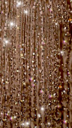 rain drops falling down on the ground in front of a brown and white wallpaper