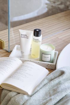 an open book sitting on top of a table next to a candle and other items