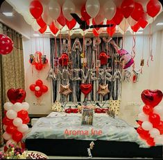 balloons and streamers fill the air above a bed in a bedroom decorated for valentine's day