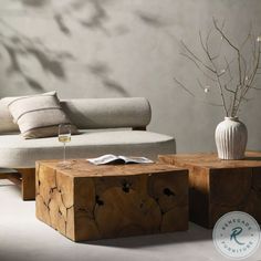 a white vase sitting on top of a wooden table next to a couch and coffee table