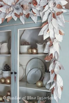 a china cabinet decorated with paper flowers and ornaments