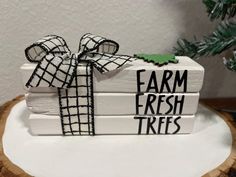 a white box with a black and green ribbon tied around it that says farm fresh trees