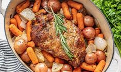 a pot filled with meat and vegetables on top of a white tablecloth next to carrots