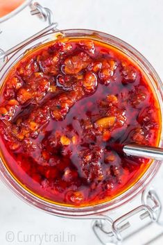 a glass bowl filled with red sauce on top of a table