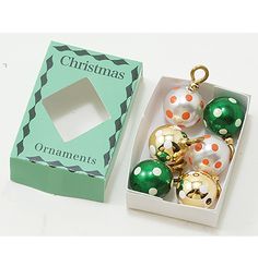 christmas ornaments are in a box on the table next to it's packaging cardboard