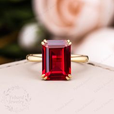 a red stone ring sitting on top of a white box